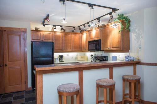 Solitudeにある1214 - Two Bedroom Standard Eagle Springs West condoのキッチン(木製キャビネット、バースツール付)