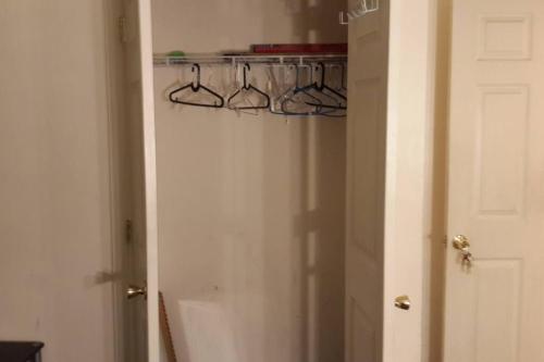 a room with a door with a closet with hangers at Large 3-Bedrooms/2-Bath Apt, One Block to Train in Brooklyn