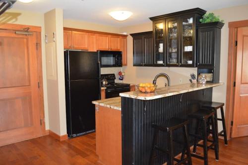 a kitchen with a black refrigerator and some bar stools at 2304- Two Bedroom Deluxe Eagle Springs East Hotel Room in Solitude