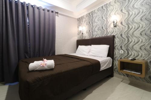 a bedroom with a bed with a black and gray wall at Flamenco Urban Living in Jakarta
