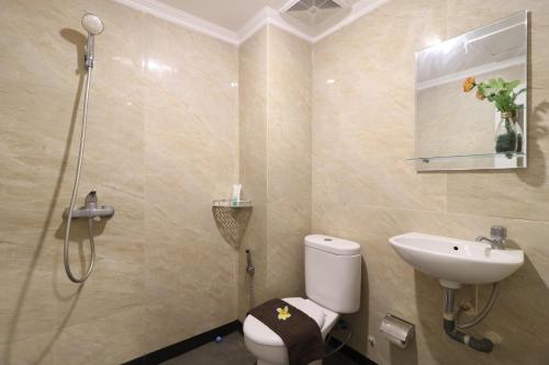 ein Bad mit einem WC, einem Waschbecken und einer Dusche in der Unterkunft Flamenco Urban Living in Jakarta