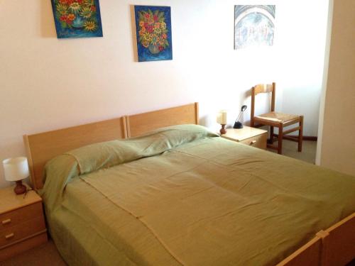 een slaapkamer met een bed en een stoel erin bij Maso Capitel Appartamento in Commezzadura
