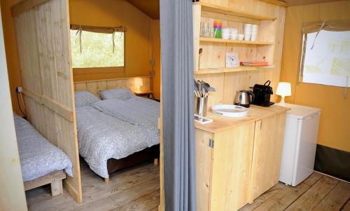 Cette petite chambre comprend un lit et une petite cuisine. dans l'établissement Lodge tent, à Montcléra