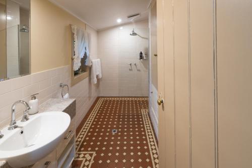 a bathroom with a sink and a tub and a toilet at Tanunda Cottages in Tanunda