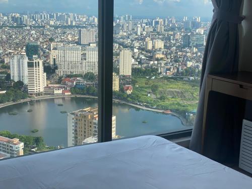 a room with a bed and a view of a city at Investland- Vinhomes Metropolis one, two, three, four bedrooms in Hanoi
