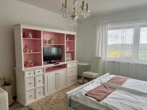 una camera da letto con un grande armadio bianco con una TV di Gold Horse Vendégház a Szilvásvárad