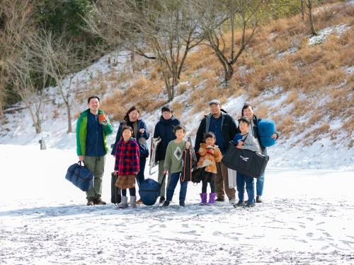 a family posing for a picture in the snow at Matsue Forest Park in Matsue