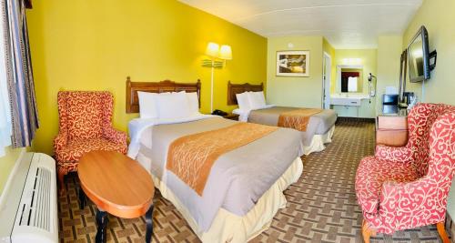 une chambre d'hôtel avec deux lits et deux chaises dans l'établissement American Inn Princeton, à Princeton