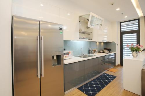 a kitchen with a stainless steel refrigerator at Investland- Vinhomes Metropolis one, two, three, four bedrooms in Hanoi