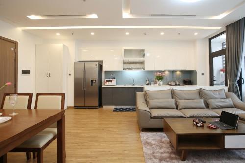 a living room with a couch and a kitchen at Investland- Vinhomes Metropolis one, two, three, four bedrooms in Hanoi