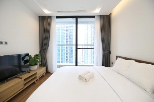 a bedroom with a large white bed and a large window at Investland- Vinhomes Metropolis one, two, three, four bedrooms in Hanoi