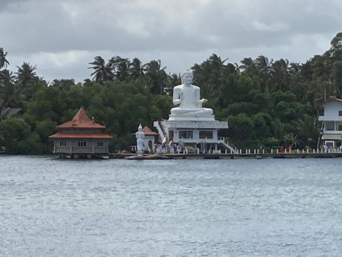 a large statue in the middle of a body of water at Channa Villa & Tours in Bentota