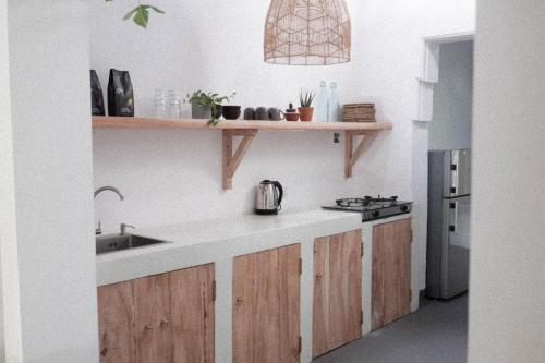 eine Küche mit Holzschränken und einem Waschbecken in der Unterkunft Clics Coliving & Coworking in Hiriketiya