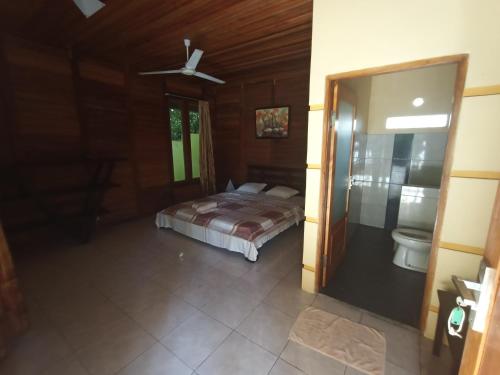 a bedroom with a bed and a toilet in it at Cakalang Resort in Bunaken