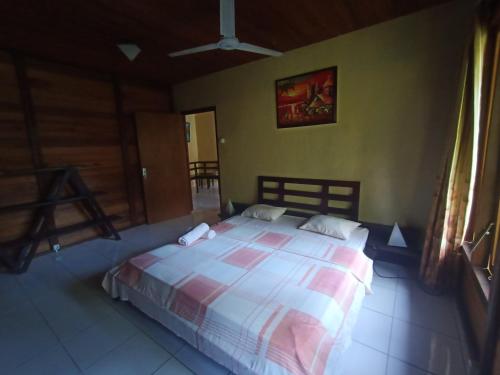 1 dormitorio con 1 cama grande en una habitación en Cakalang Resort, en Bunaken