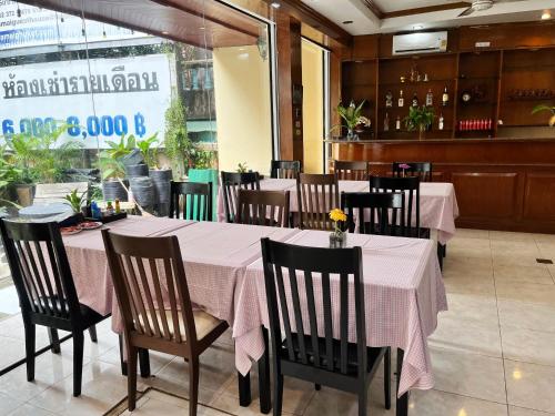 a restaurant with tables and chairs with pink table cloth at Patong Lamai Residence in Patong Beach