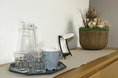 a tray with glasses and a vase on a counter at Penzion Marjána in Mníšek pod Brdy