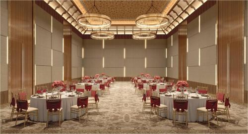 a banquet hall with white tables and red chairs at Taj Wayanad Resort & Spa, Kerala in Wayanad