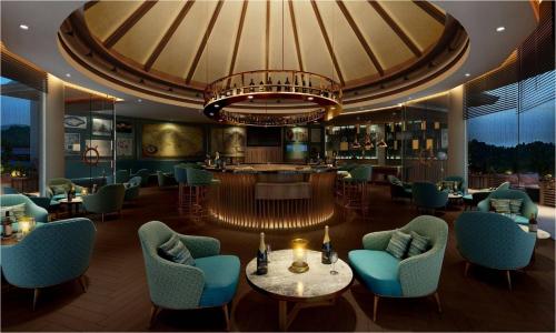 a restaurant with chairs and tables and a chandelier at Taj Wayanad Resort & Spa, Kerala in Wayanad