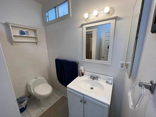a bathroom with a toilet and a sink and a mirror at Aparment Rosarito Beach Downtown (C) in Rosarito