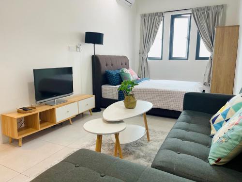 uma sala de estar com um sofá e uma televisão em Meritus Residensi, Prai Penang em Perai