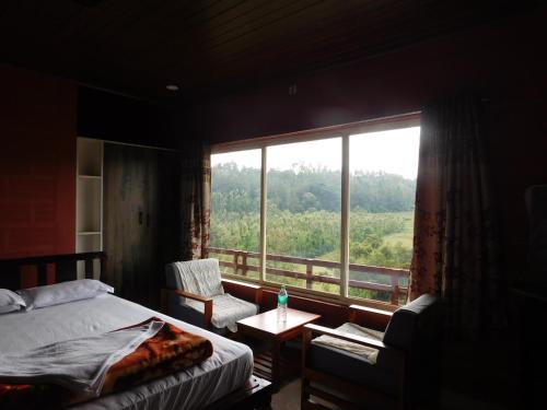 a bedroom with a bed and a large window at Cauvery Homestay in Somvārpet
