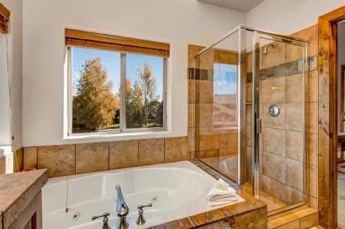 a bathroom with a tub and a shower and a window at Cedar Haven in Park City