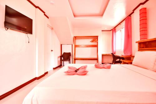 Un dormitorio con una cama con almohadas rosas. en Nigi Nigi Too Beach Resort en Boracay