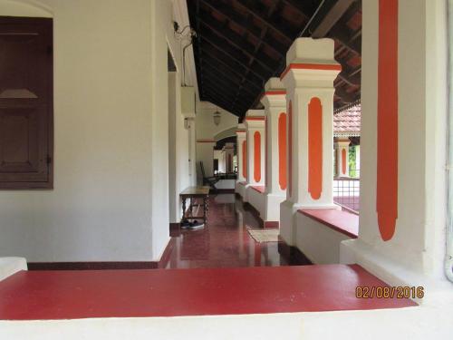 an empty corridor of a building with red and white walls at Srivilas in Pudunagaram