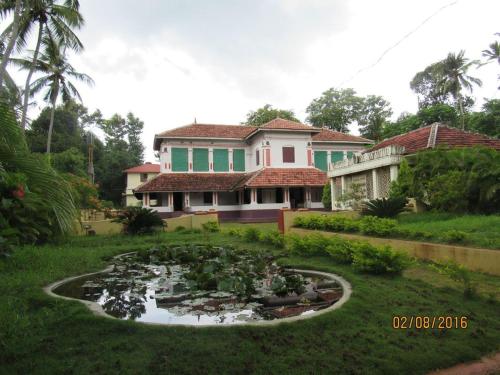 a house with a pond in front of a house at Srivilas in Pudunagaram