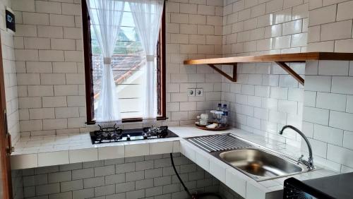 a kitchen with a sink and a window at Omatha Village in Denpasar