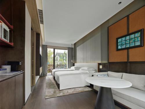 a hotel room with two beds and a table at HOMM Huzhou Xisai Shan in Huzhou