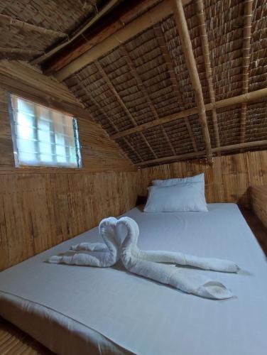 Virgin River Resort and Recreation Spot في Bolinao: سرير فوطه تشكيل قلب عليه