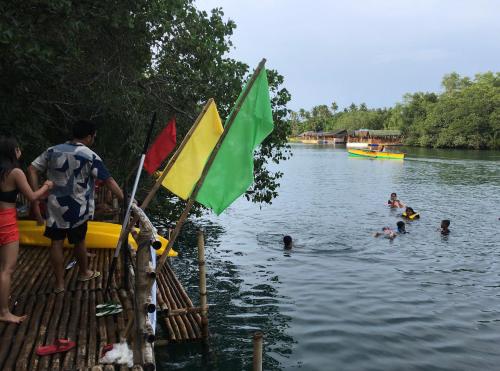 a group of people in the water with flags at Virgin River Resort and Recreation Spot in Bolinao