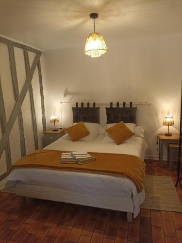 une chambre avec un grand lit et un lustre dans l'établissement Le logis du clocher, à Troyes