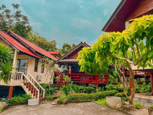 a house with a garden in front of it at Tanouy Garden in Baan Khai