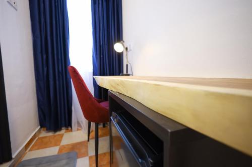 a room with a counter and a red chair at RENTIO HOTEL in Kulim