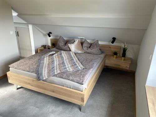 a bedroom with a large wooden bed with pillows at Zimmermanns 2 in Monschau