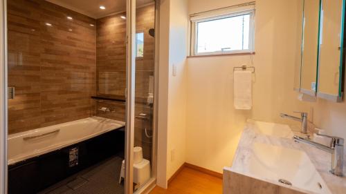 a bathroom with a bath tub and a sink at Annupuri Chalets - Niseko in Niseko