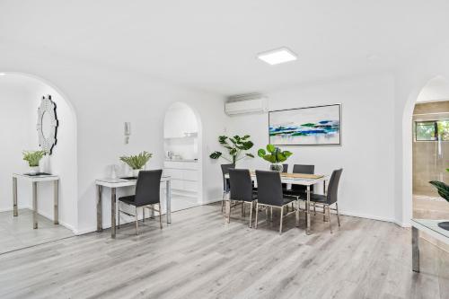 a dining room with white walls and a table and chairs at Coco Bella Retreat in Central Surfers - sleeps 6-8 in Gold Coast