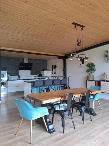une salle à manger avec une table et des chaises en bois dans l'établissement Villa des 3 chênes, à Plouénan
