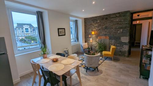 uma sala de estar com uma mesa e cadeiras e uma lareira em Les Appartements de Viarmes et de Guernisac em Morlaix