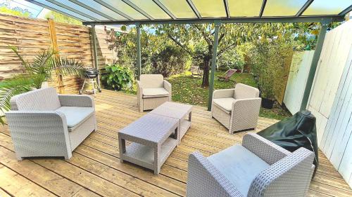 a wooden deck with chairs and a table and chairs at Location maison Jardin Gîte Angers Les Ponts de Cé in Les Ponts-de-Cé