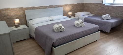 a bedroom with two beds with towels on them at Come nelle favole home in Bari