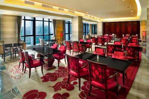a restaurant with red chairs and tables in a room at Crowne Plaza Shenzhen Longgang City Centre by IHG in Longgang