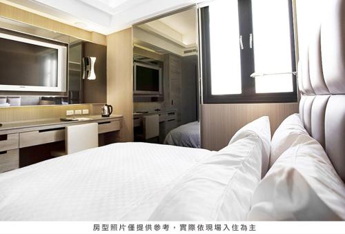 a hotel room with a bed and a television at Royal Group Hotel Ho Yi Branch in Kaohsiung