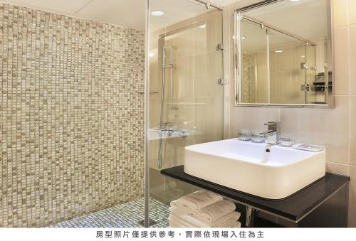 a bathroom with a sink and a shower at Royal Group Hotel Chang Chien Branch in Kaohsiung