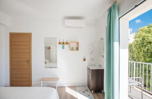 1 dormitorio con 1 cama y balcón en Forenna Hostel, en El Arenal