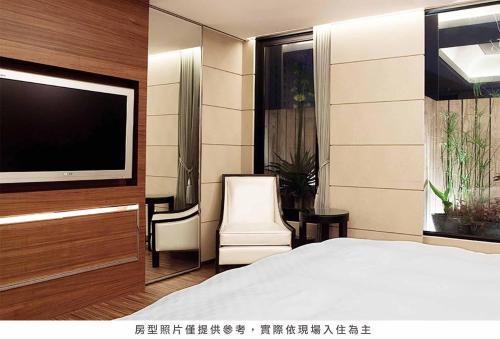 Un dormitorio con una cama y un televisor de pantalla plana. en Royal Group Hotel Chun Shan Branch, en Kaohsiung