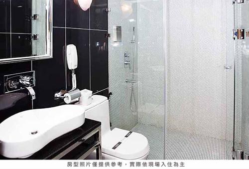 y baño con ducha, aseo y lavamanos. en Royal Group Hotel Chun Shan Branch, en Kaohsiung